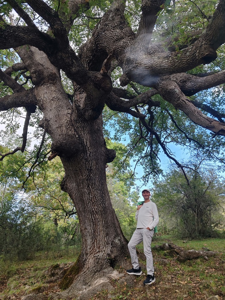 Emanuele Bonin accanto a un grande albero